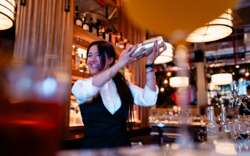 Woman making cocktails at the bar